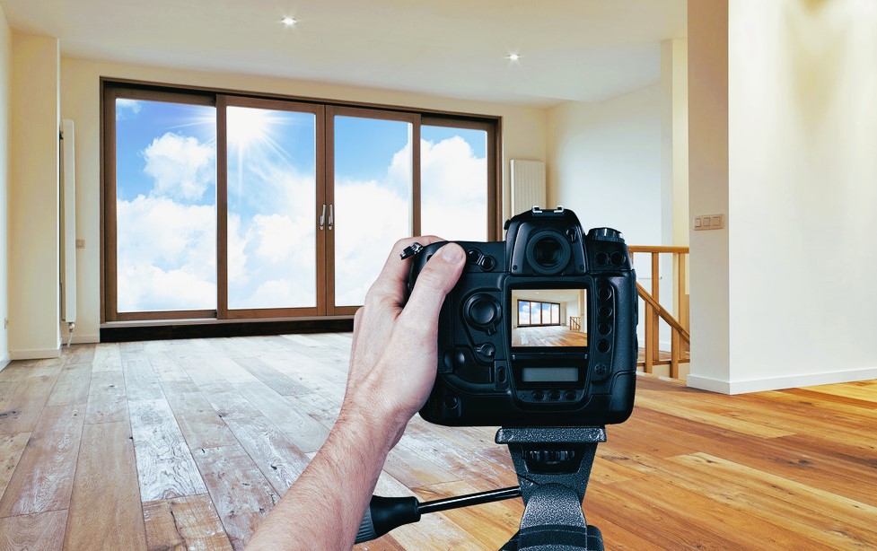 Man photographing empty living room with digital camera